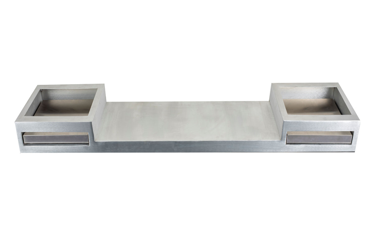 A rectangular metallic object with a wide central platform, resembling a TableCraft double burner. Two square compartments with front slots sit on either side. The symmetrical, industrial design features a smooth steel-like finish against a plain white background.