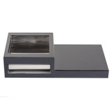 A modern, rectangular tabletop ashtray with a sliding lid—perfect for your Action Station. Glossy black with a smaller square metal tray on the left and a flat single burner section on the right. Features a shiny metallic pull-out drawer in front.