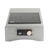 The TableCraft Products Induction Station features a stainless steel single burner cooktop with a black glass surface, a front control panel with a gold knob, and labeled settings. Its compact, modern design adds professional appeal to any space.