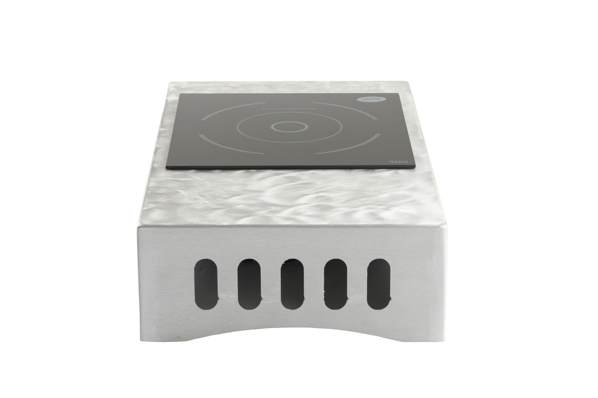 A single-burner Induction Station by TableCraft Products features a glossy black cooking surface atop a silver metallic base with vertical ventilation slots. Circular guidelines for pot placement are visible, all viewed from the front at eye level.