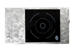 A rectangular, silvery textured metal surface with a shiny finish features a TableCraft Products Induction Station, showcasing a black glass single burner cooktop with white circular outlines, touch controls, and a round badge labeled INDUCTION.