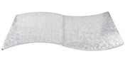 A flat, metallic sheet with a smooth, reflective surface and a wavy, S-shaped curve resembles an elegant serpentine table cover. Its circular, textured pattern catches the light for a shimmering effect against the white background.