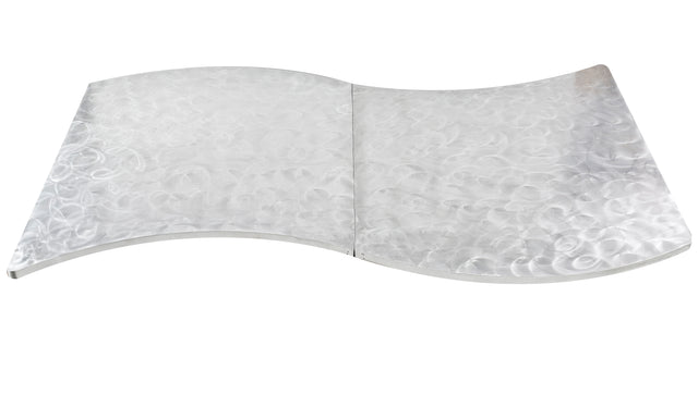A flat, metallic sheet with a smooth, reflective surface and a wavy, S-shaped curve resembles an elegant serpentine table cover. Its circular, textured pattern catches the light for a shimmering effect against the white background.