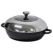 A black, round die-cast aluminum casserole dish with two handles and a shiny, stainless steel domed lid featuring a round handle on top. The lid has small steam holes, and the dish sits on a white surface with reflections visible.