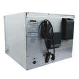 A large silver industrial convection oven with a black Unox-branded soap or sanitizer dispenser mounted on its side, a coiled electrical cord, warning labels, control buttons, and indicator lights on the metal panel. The background is white.