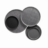 Three round trays are arranged overlapping on a white background. Two trays, crafted from fiberglass, have a subtle crisscross texture, while two smaller, smooth Serving Camtrays—dishwasher safe—are nested inside the larger trays.