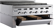 A commercial stainless steel Vulcan charbroiler with four control knobs, grates on top, and a front drawer partially open showing several wooden planks inside. The clean, sturdy design features a Wood Assist Achiever Smoker Base for professional kitchens.