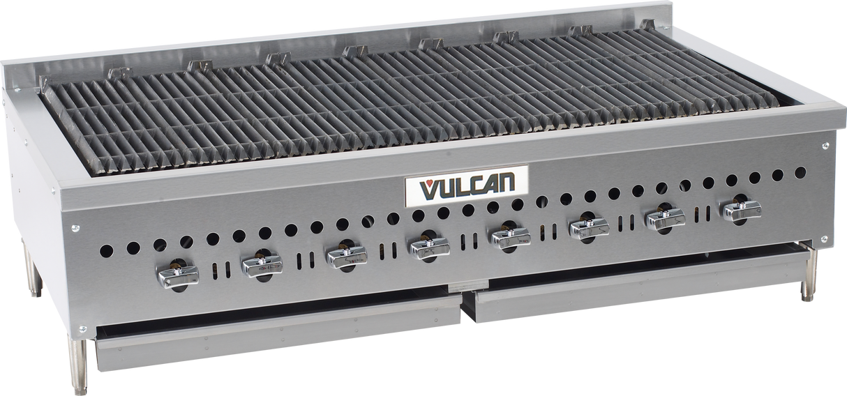 A large, stainless steel gas countertop charbroiler with six control knobs, a wide grilling surface with cast iron burners, and ventilation holes along the front. The “Vulcan” brand name is centered on the front panel. The unit stands on short legs.