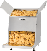 A stainless steel Vulcan VCW46 top load chip warmer filled with yellow corn tortilla chips. Chips are visible in both the top storage area with open lids and the bottom serving area, ready to be dispensed. The unit is elevated on metal legs.