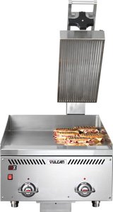 A commercial Vulcan sandwich press with an open top plate and thermostatic control, grilling several panini sandwiches on the flat bottom grill plate. The stainless steel machine features two control dials and indicator lights on the front panel.