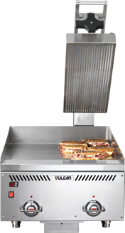 A commercial Vulcan sandwich press with an open top plate and thermostatic control, grilling several panini sandwiches on the flat bottom grill plate. The stainless steel machine features two control dials and indicator lights on the front panel.