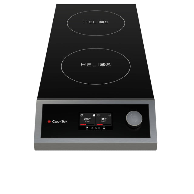 A black and silver double induction cooktop with a portable design features two circular burners labeled “HELIOS.” The front panel offers a digital display, single control knob, CookTek logo, and a red indicator light.
