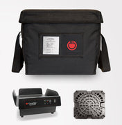 A black insulated food delivery bag with a shoulder strap, clear label pocket, and red hot food icon is shown above two devices: an induction charger-powered portable heating unit and a black vented plastic tray from the ThermaCube Delivery System.