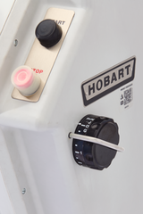 Close-up of a white Hobart Cutter Mixer panel with a large black knob labeled “RUN” and “OFF,” red-lit STOP button, black START button, metallic HOBART nameplate with QR code underneath—designed for use with a 45 qt capacity stainless steel bowl.