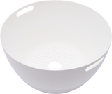 A white, round plastic bowl with a smooth surface, two oval handles on opposite sides, and small drainage holes at the center, resembling a colander. Similar in function to a stainless steel bowl used in Hobart Cutter Mixers. The bowl is empty and set against a white background.