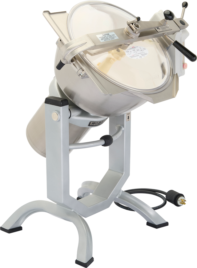 A large, industrial stainless steel food processor, the Hobart HCM450-62 features a transparent lid, black handles, control dial, and sturdy metal legs. Tilted upward to reveal its deep mixing bowl, it includes an electrical cord and a Cutter Mixer for versatility.