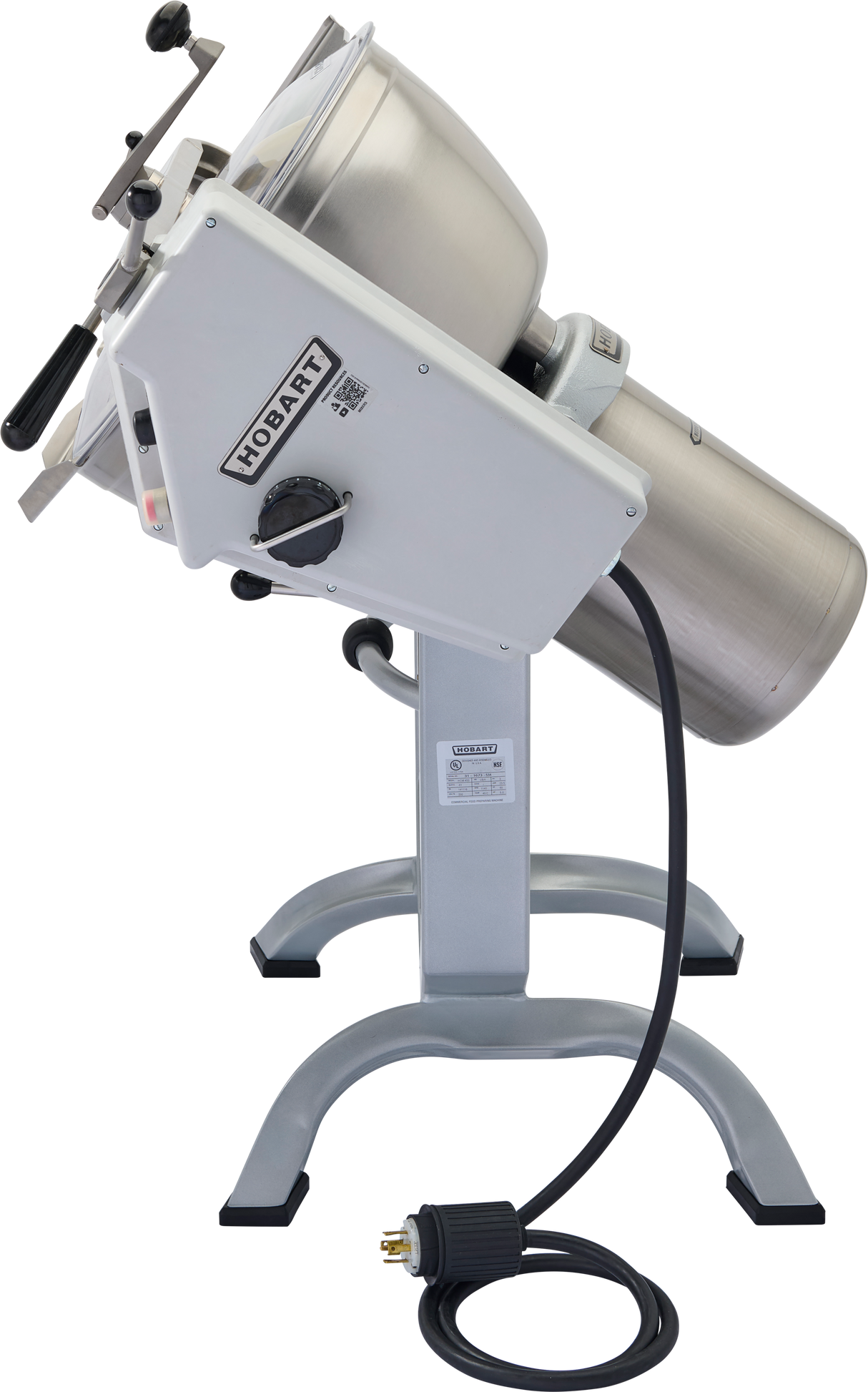 A Hobart HCM450 Cutter Mixer food processor with a tilted stainless steel mixing bowl and mix attachment, mounted on a sturdy gray stand. The coiled power cord sits on the floor. Adjustment knobs, levers, and a Hobart label are visible.