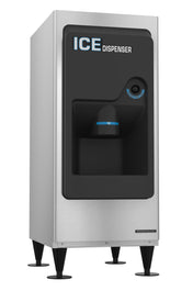 A stainless steel commercial Ice Dispenser with black front panel, labeled “ICE DISPENSER” in white and blue letters. This ADA compliant machine features a chute for dispensing ice, 130-lb. storage capacity, and stands on four black adjustable legs.