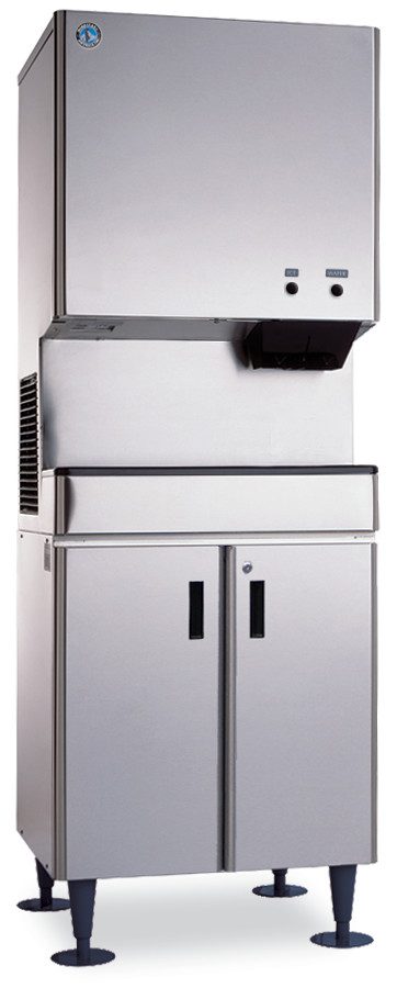 A large commercial stainless steel cubelet-style ice maker with a boxy top section for ice-making, a front dispensing area, and a lower cabinet with two vertical handles, resting on four black adjustable legs. The unit has a modern, industrial appearance.