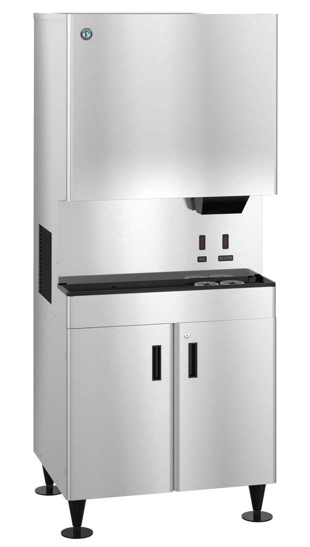 A large, stainless steel Hoshizaki DCM-752BAH-OS cubelet ice dispenser with a top ice bin, two dispensing buttons, a black drip tray, and storage cabinet below. The machine stands on four black legs and features a minimalist, industrial design.