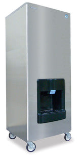 A tall, rectangular, stainless steel Hoshizaki ice dispenser with a black dispensing area is shown. The machine stands on four wheels for mobility, has a blue button above the chute, and dispenses Crescent Cube-Style ice for commercial or industrial use.