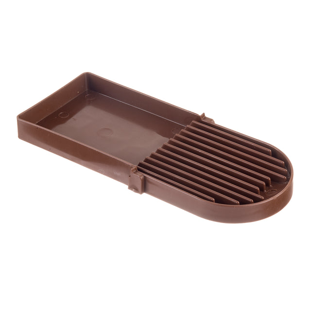 A brown plastic slicer with a flat rectangular base and parallel raised ridges on one half, designed to cut or slice food items evenly. Dishwasher safe and made in USA, its slightly raised edges help keep items securely in place.