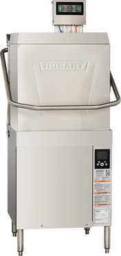 A Hobart commercial dishwasher with a stainless steel exterior features digital controls, a handle across the upper front, and an electronic display screen. This door type dishwasher includes detailed safety and operation labels on the lower front panel.