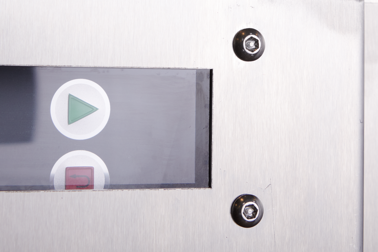 A close-up of a metallic control panel on a low energy dish machine with a rectangular display showing two buttons: a green triangle (start) and a red square (stop). The brushed metal surface hints at advanced energy recovery technology.