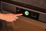 A hand presses a glowing green start button on a stainless steel Advansys high temperature sanitizing undercounter dishwasher with a digital display showing a draining cycle. The dark stone countertop sits above this ENERGY STAR model.