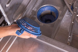 A hand holds a blue cylindrical dishwasher filter above the metal interior of an undercounter dishwasher, showing the filter compartment and spray arm. The filter is partially removed, highlighting routine Advansys Dishwasher maintenance.