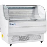 A white Empura refrigeration open air merchandiser with a curved glass front, open shelving, LED top lighting, a vented lower section, and casters for mobility. The interior is empty and clean, ready for displaying food items.