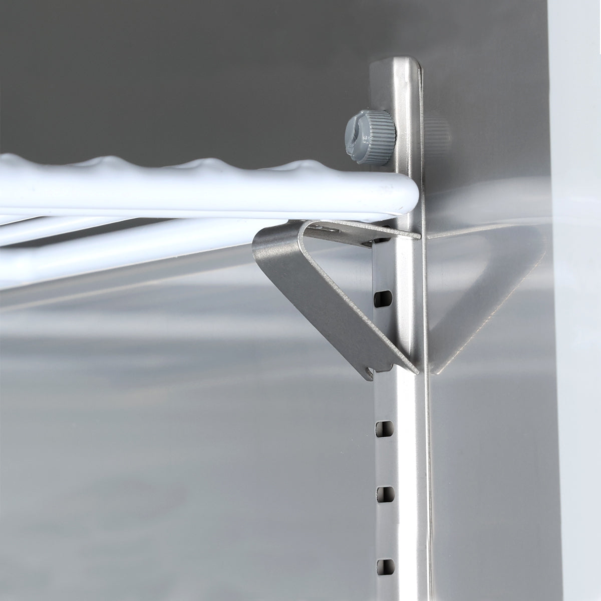 Close-up of a metal shelf bracket attached to a support rail with multiple holes for adjustable height in an Empura Refrigeration reach-in refrigerator. A white wire shelf rests on the bracket. The metallic background is slightly reflective.