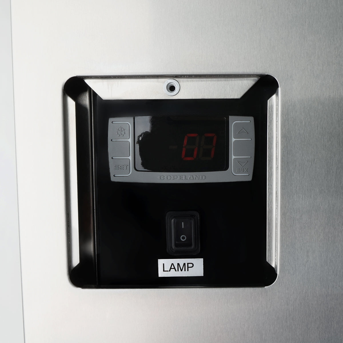 A close-up of a digital control panel on a metallic surface, likely from an Empura refrigeration back bar cooler, featuring a display showing “-01,” arrow and set buttons, and a black switch labeled “LAMP” below the panel. The brand “Goodland” is faintly visible.