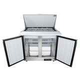 A commercial freezer with two front doors open showing wire shelves inside, and a top lid lifted to reveal several stainless steel food storage containers; the exterior is white with black trim, ideal as a Refrigerated sandwich prep table from Empura refrigeration.
