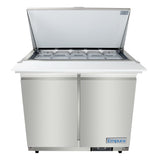 A stainless steel Empura refrigerated sandwich prep table with an open top lid reveals multiple covered metal food pans in rows. Two doors sit below a white cutting board across the front, and the Empura refrigeration brand is visible on the bottom right.