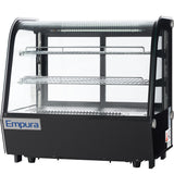A black and glass Empura refrigerated display case with two wire shelves, clear curved front and sides, and an interior light, designed for showcasing food items in a commercial setting. The unit sits on four small legs.