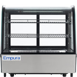 A commercial Empura refrigerated display case with a curved glass front, three chrome wire shelves, interior lighting, and stainless steel base. This countertop display refrigerator is perfect for showcasing food or desserts.