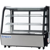 A commercial Empura refrigerated case with glass panels, two metal wire shelves, interior LED lighting, and a stainless steel base. The countertop display refrigerator is empty and designed for showcasing food items. Brand name “Empura” appears on the front.
