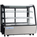 A commercial Empura refrigerated display case with glass sides and front, two wire shelves, and a metal lower panel. This illuminated countertop display refrigerator is designed to showcase food items professionally.