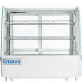 A white Empura refrigerated display case with three empty wire shelves, curved glass sides, interior LED lighting, and a front label displaying the Empura logo. This countertop display refrigerator is clean and ready for showcasing food or beverages.