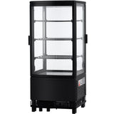 A black, upright refrigerated display case with four clear glass sides and multiple wire shelves. The door is closed, and the fridge appears empty. A small warning label is visible on the lower front panel near the base of the appliance.