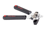 A FirmGrip Hand Can Opener with black, textured ergonomic handles labeled “FIRM GRIP” in red. The handles have red circular accents, while the cutting mechanism and gears are shiny stainless steel, and the turning knob is black plastic.