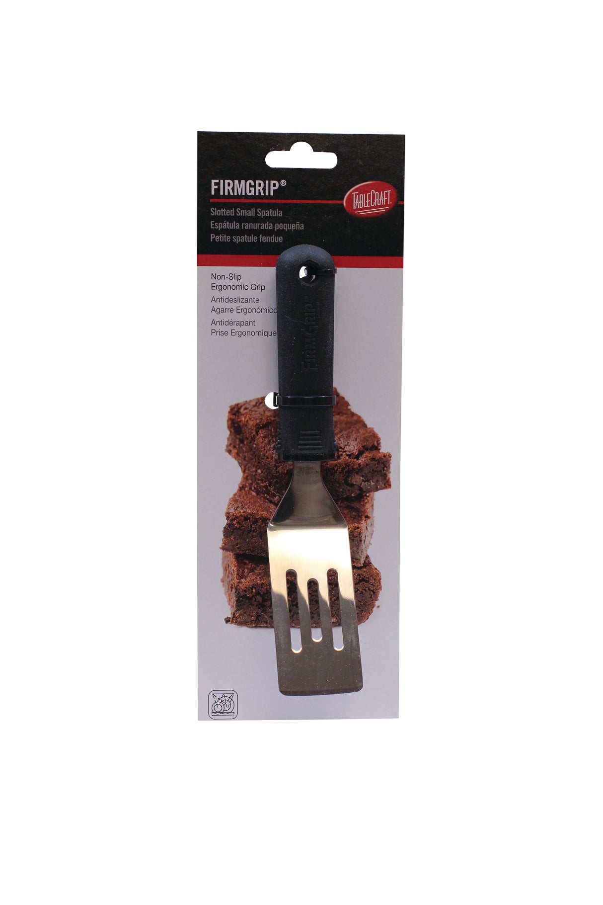A slotted metal FirmGrip spatula with a black handle is attached to packaging featuring chocolate brownies. The packaging highlights the ergonomic, non-slip grip and notes that this dishwasher safe spatula is described in English, French, and Spanish.