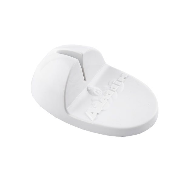 A white, oval-shaped plastic object with a central slot and raised ridge, featuring embossed text and a small logo. The base is flat and smooth, while the upper part arches slightly. It appears to be a TableCraft Knife Sharpener.