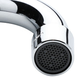 Close-up of a shiny, stainless chrome wall mount faucet spout with a black honeycomb-pattern aerator at the tip. The highly reflective surface shows subtle highlights and faint reflections against a plain white background.