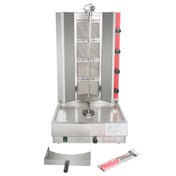 A vertical stainless steel gas broiler with a central rotating spit, four red control knobs on the right, a drip tray below, and accessories including a meat scoop and a knife in packaging placed in front of the machine.