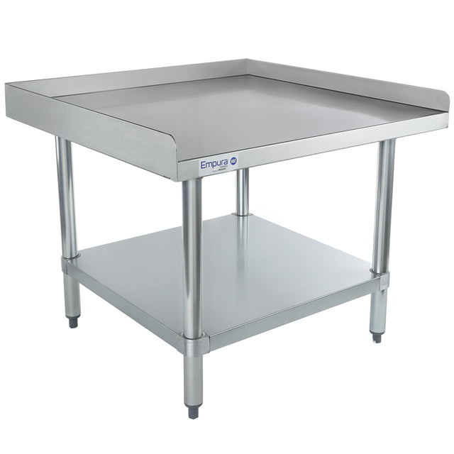 A stainless steel work table with NSF certification features a raised edge on three sides, a flat work surface, and a lower shelf. This Empura equipment stand has sturdy cylindrical legs, adjustable feet, and the brand logo on the front against a plain white background.