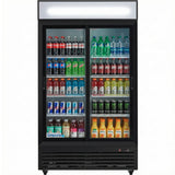 A refrigerated merchandiser with glass sliding doors is stocked with assorted drinks—sodas, bottled water, sports drinks, Monster energy drinks, and a row of orange and lemonade juice bottles. The Empura brand appears at the bottom of the door.