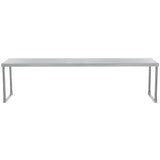 A long, rectangular, stainless steel table with a flat top and four straight legs. The table has a minimalist, industrial design and is shown against a plain white background.