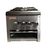 A stainless steel Empura commercial natural gas range is viewed from the front. Four black control knobs line the center, and above them are cast iron burner grates. Below the knobs is an open storage compartment. The background is completely white.